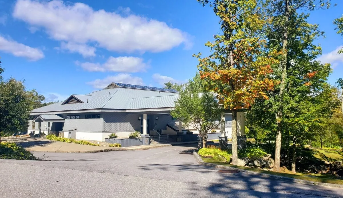 A view of modern architecture set amid landscaped gardens and a canopy of trees. The open, sunlit space beckons for outdoor gatherings, strolls, or simply appreciating the environment.